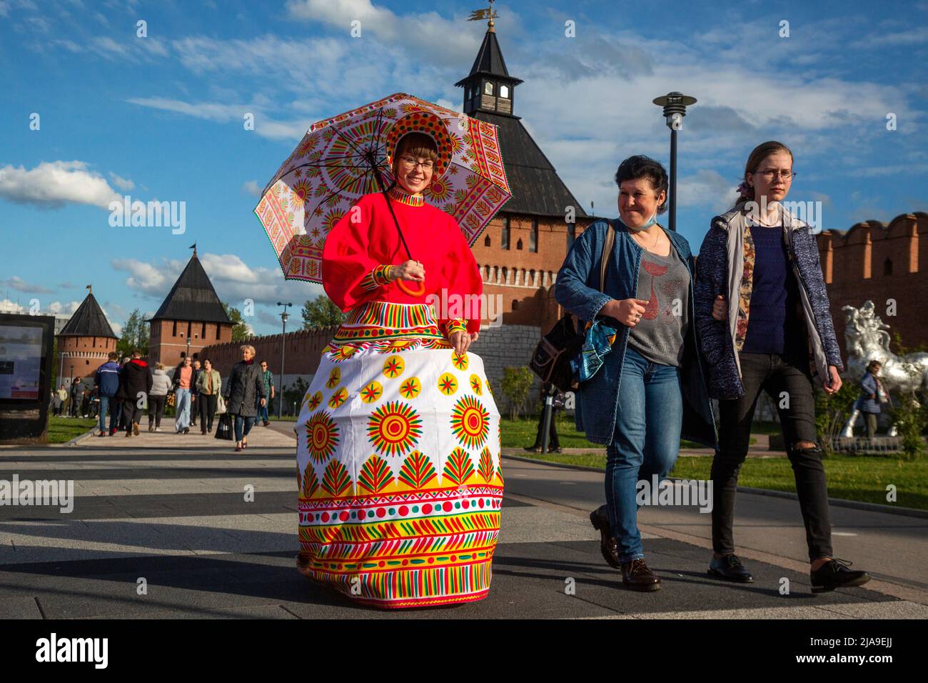 Tula, Russia. 28th May, 2022. A girl in a costume stylized as a Filimonov clay toy walks along the central embankment against a background of the Kremlin in Tula, Russia Stock Photo