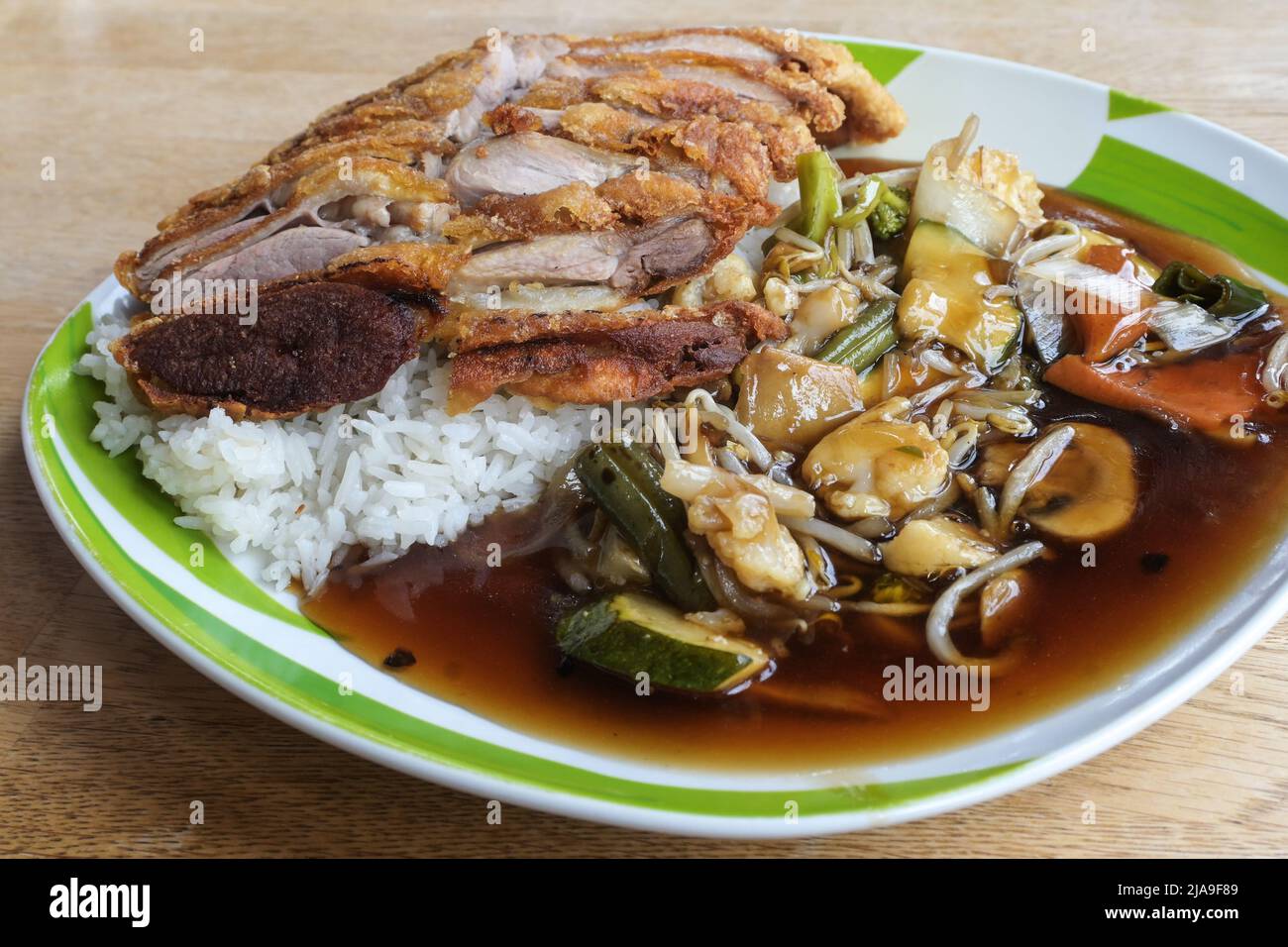 crispy fried duck meat on rice with vegetables and sauce, Chinese dish