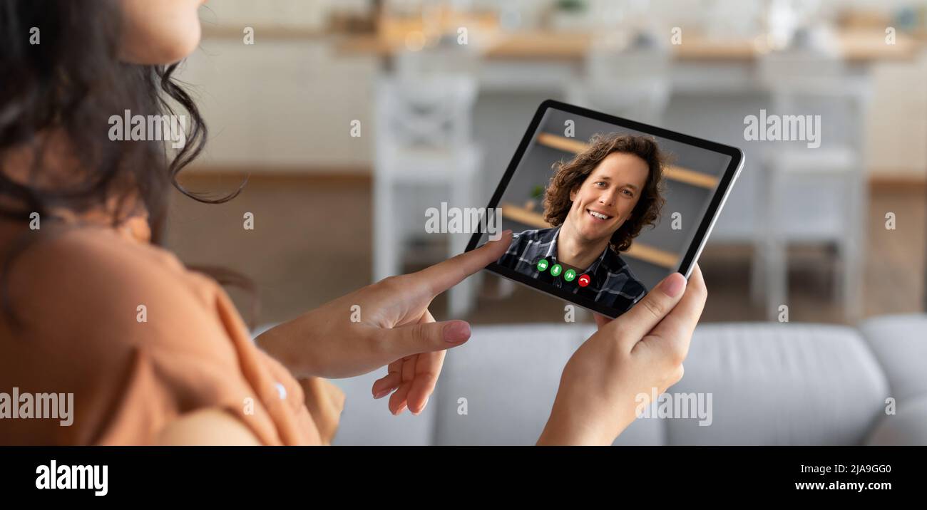 Young brunette woman using tablet computer to call boyfriend Stock Photo