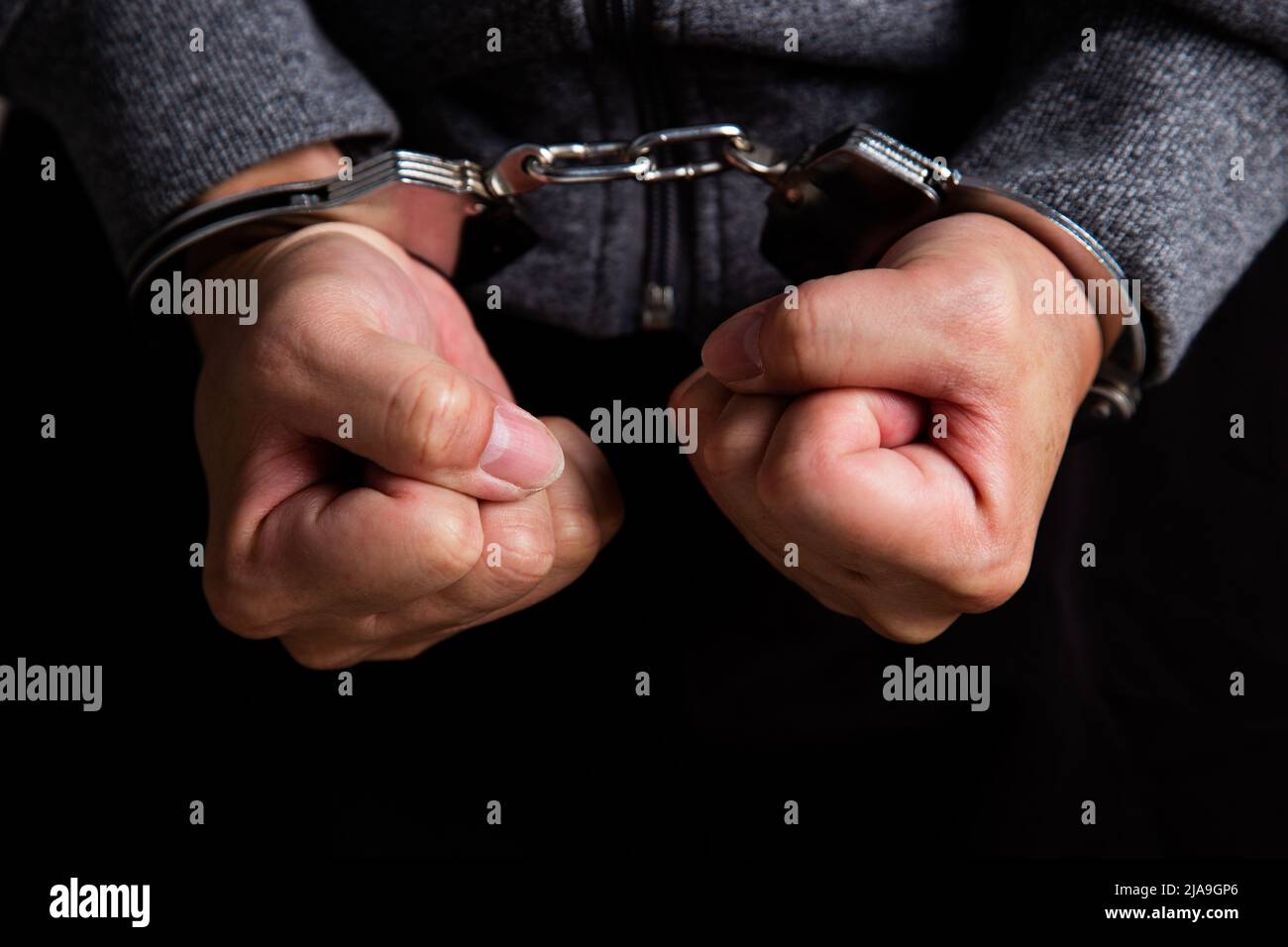 Criminal hands locked in handcuffs Stock Photo Alamy