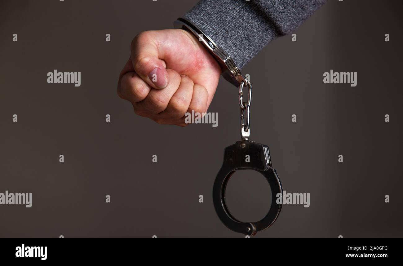 Criminal hands locked in handcuffs Stock Photo Alamy