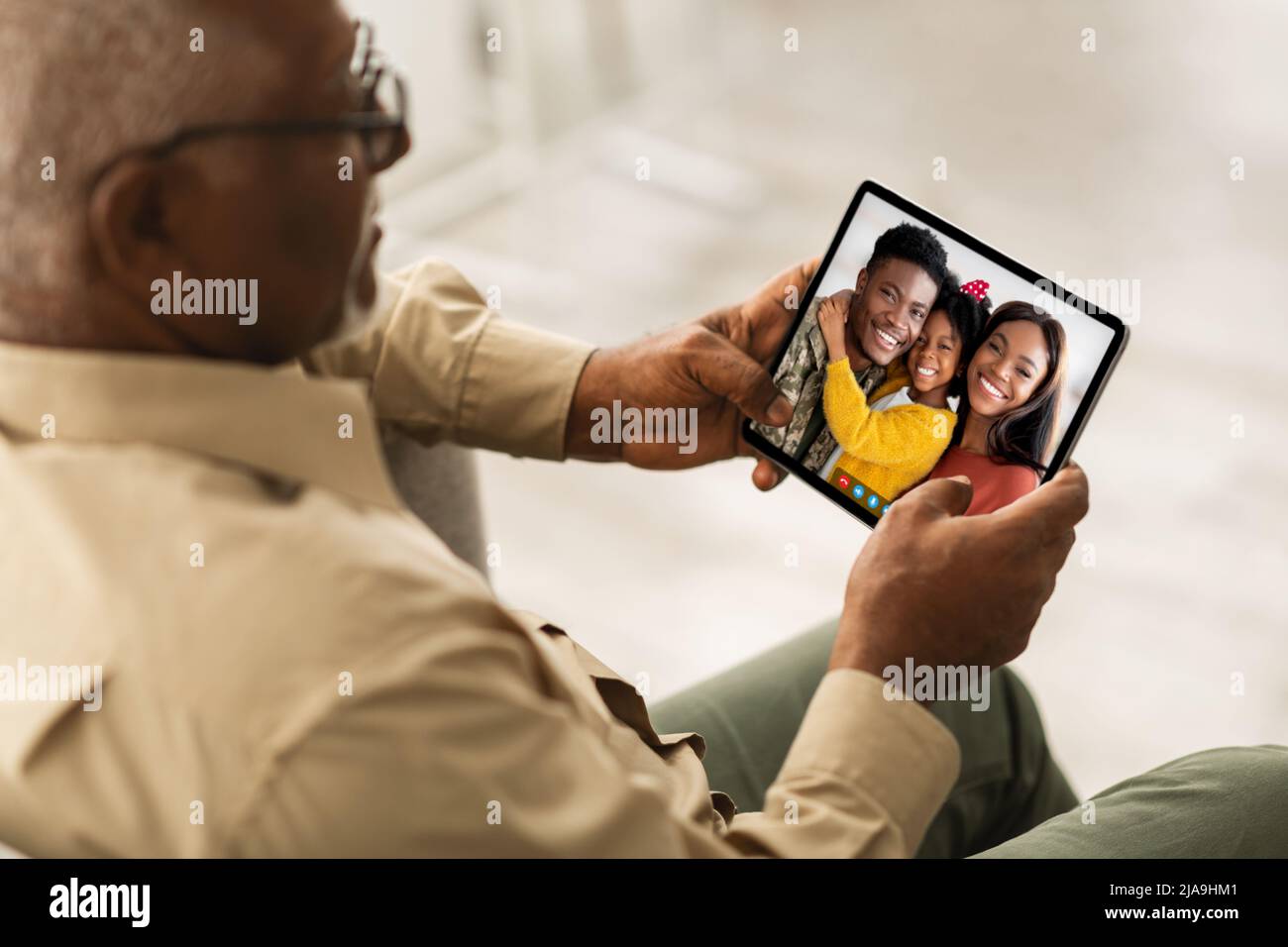 Senior black man calling his family, using digital tablet Stock Photo