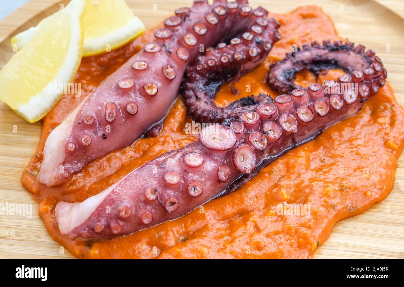 Roasted octopus tentacles with chilli romesco sauce Stock Photo