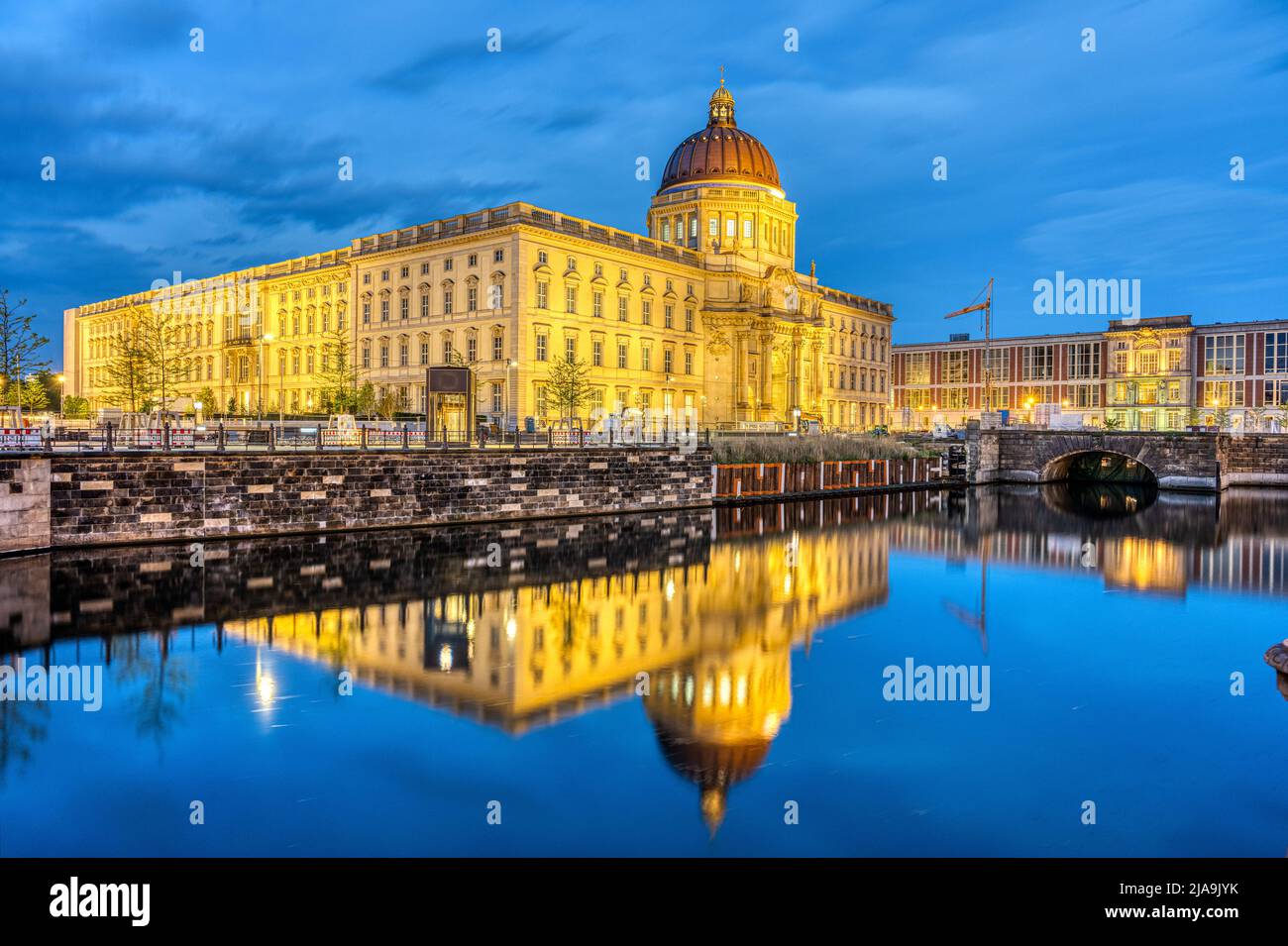 The imposing reconstructed City Palace in Berlin at night reflected in a small canal Stock Photo