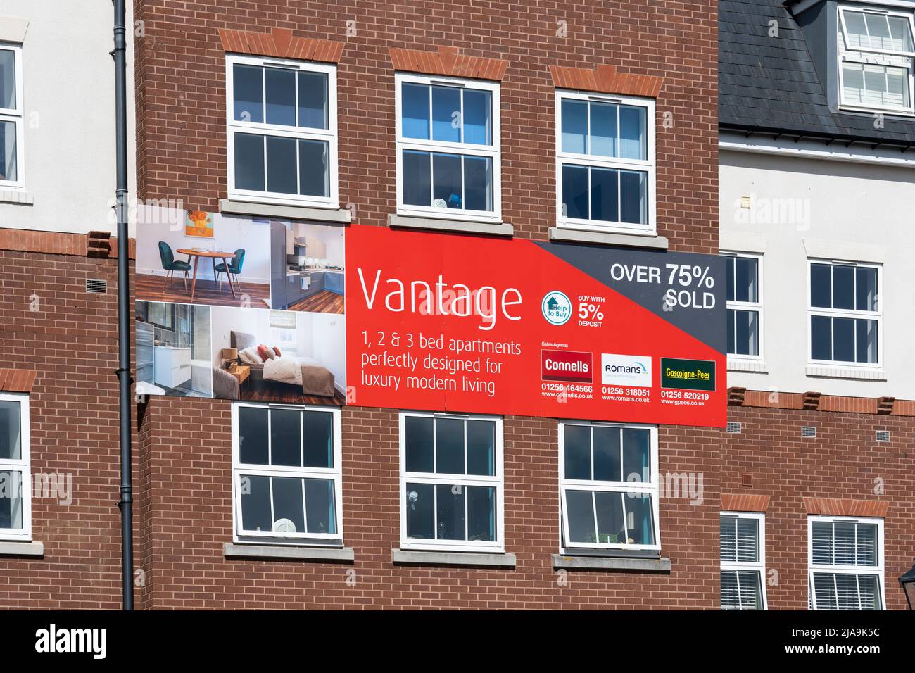 An advertising banner on the outside of Vantage House advertising new 1, 2, 3 bed apartments / flats for sale. Basingstoke town centre, England Stock Photo