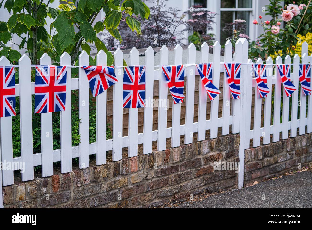 29 May 2022: Union Jack bunting on white picket fence, London Stock ...