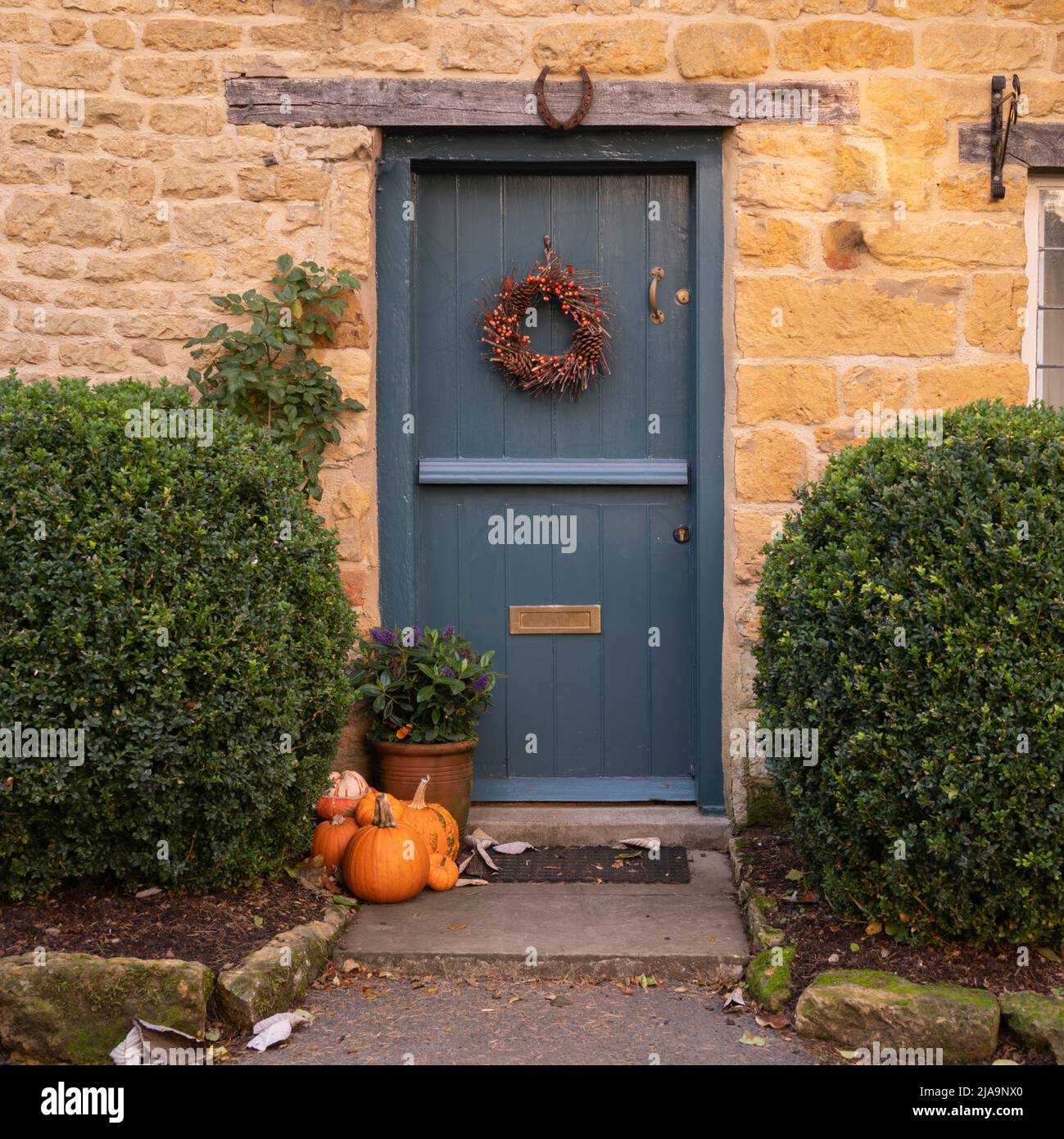 Cotswold cottage door with pumpkins, England. Stock Photo