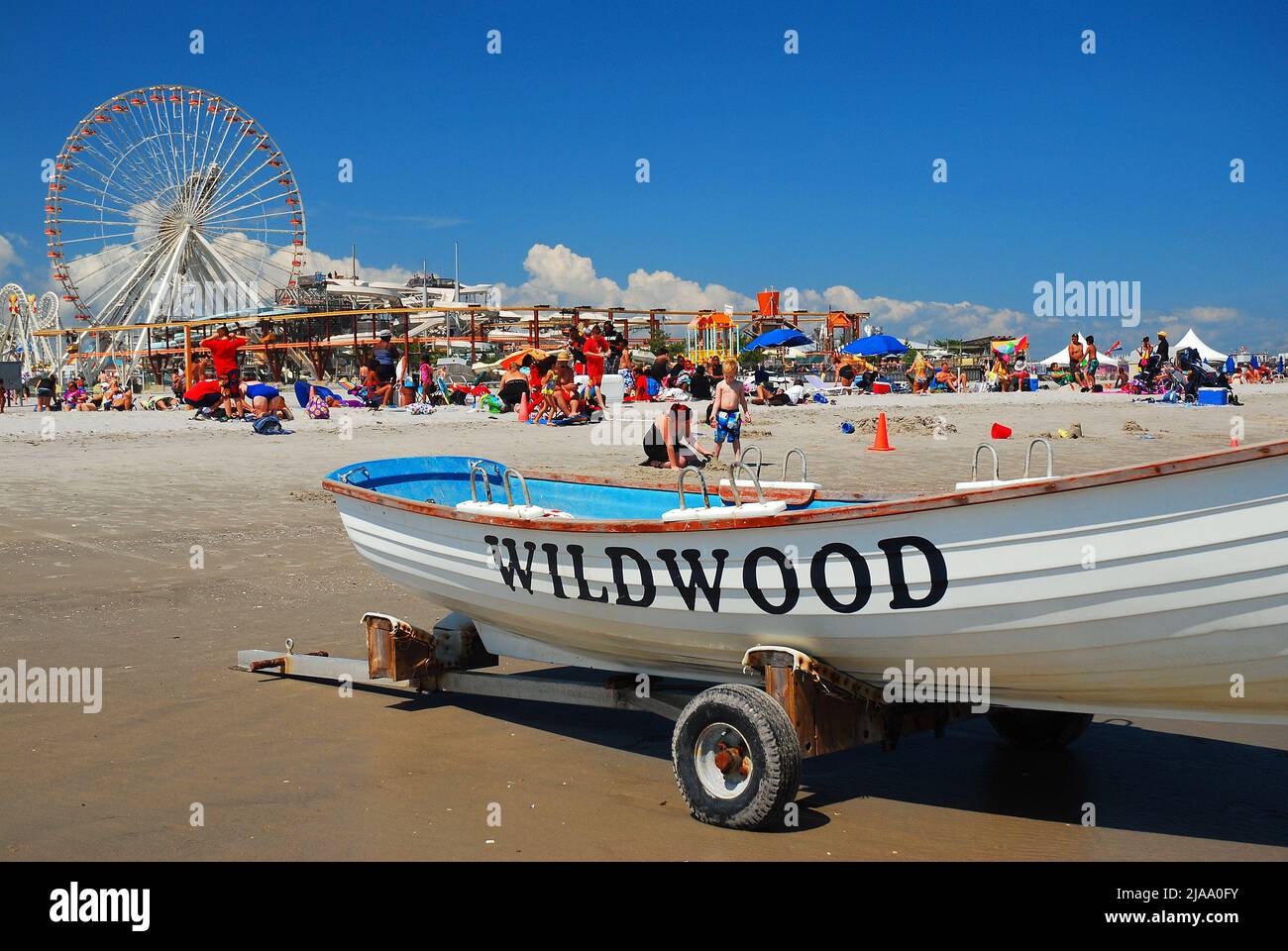 A typical sunny summer vacation day brings the on the sands of Wildwood, on  the Jersey Shore, with the pier rides in the background Stock Photo - Alamy