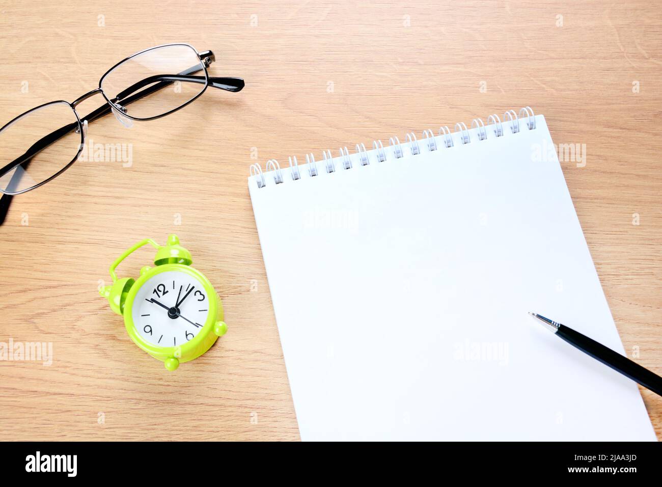 Close up of blank notebook and pen with clock on a desk Stock Photo