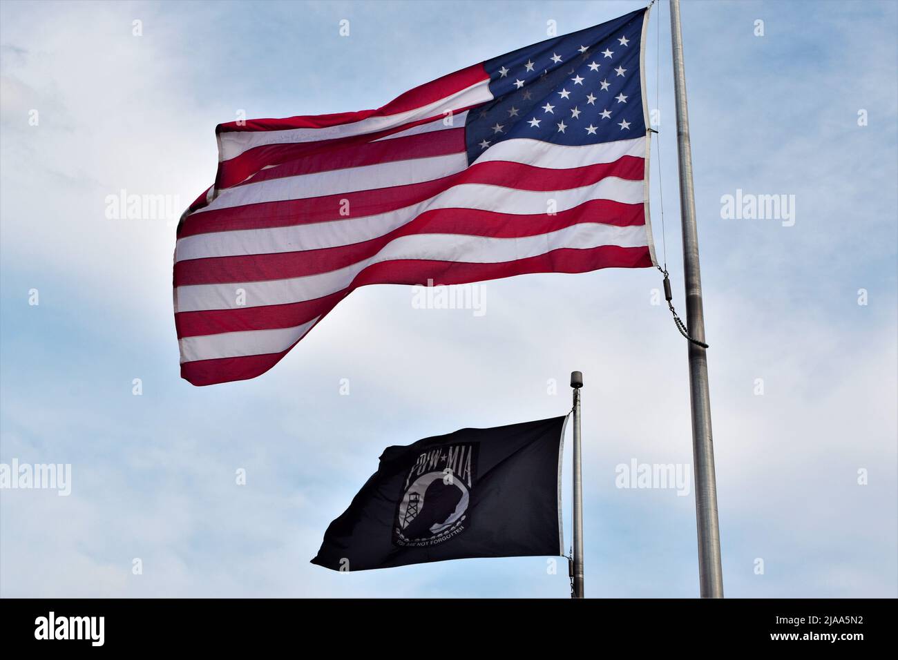 An American Flag and POW-MIA Flag at a Roadside Veterans memorial in Wisconsin, USA Stock Photo
