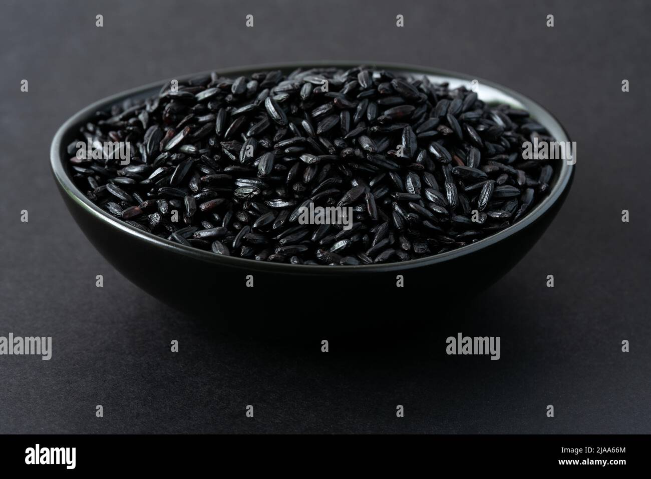Uncooked Black Heirloom Rice in a Bowl Stock Photo