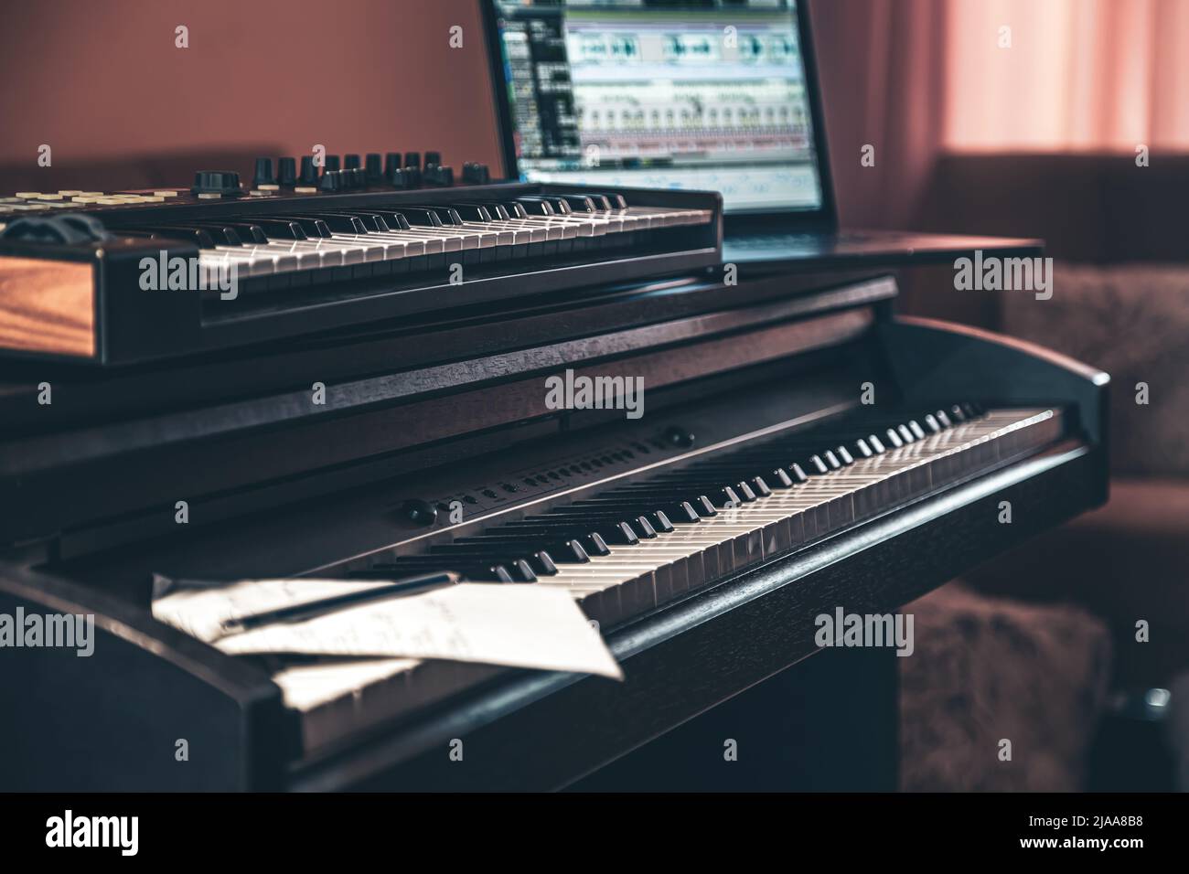 Electronic piano and guitar in room interior. Stock Photo