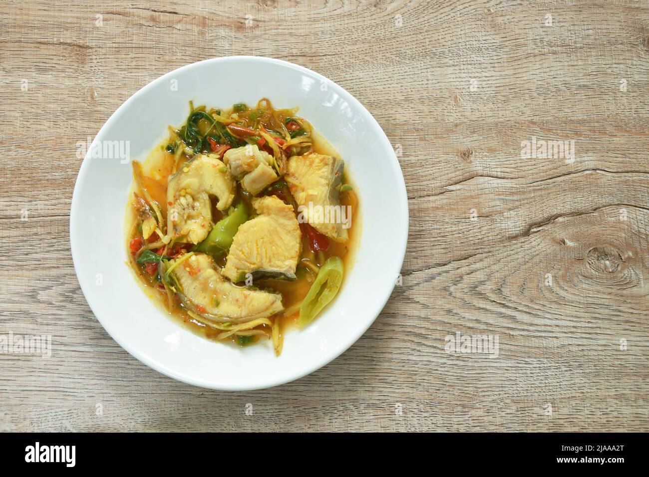 spicy fried Asian redtail catfish with herb and chili on plate Stock Photo