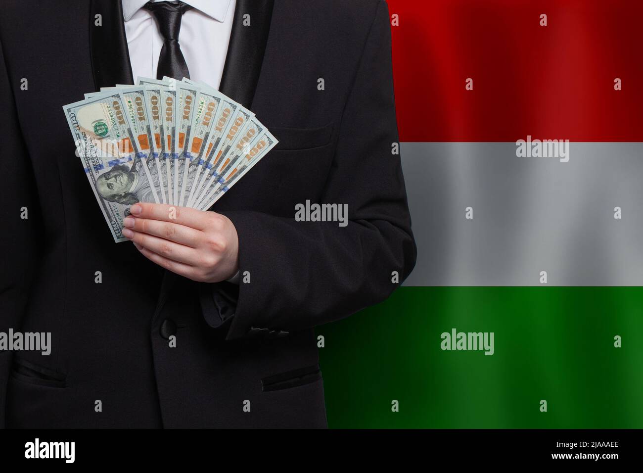 100 US dollar bills money banknotes in hand against flag of Hungary background Stock Photo