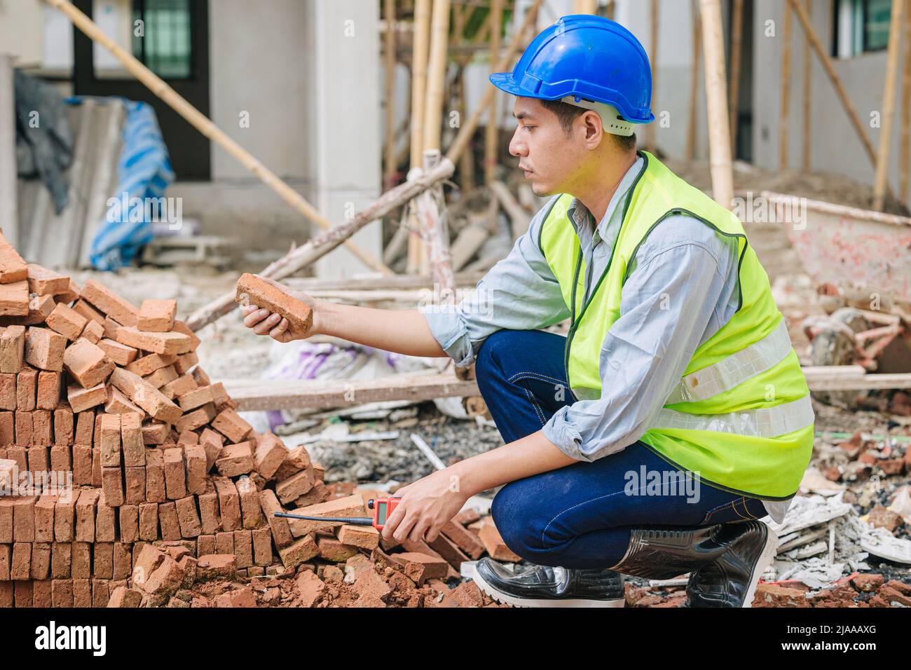 Engineer foreman manager quality check Burnt Clay Bricks for good construction building project Stock Photo