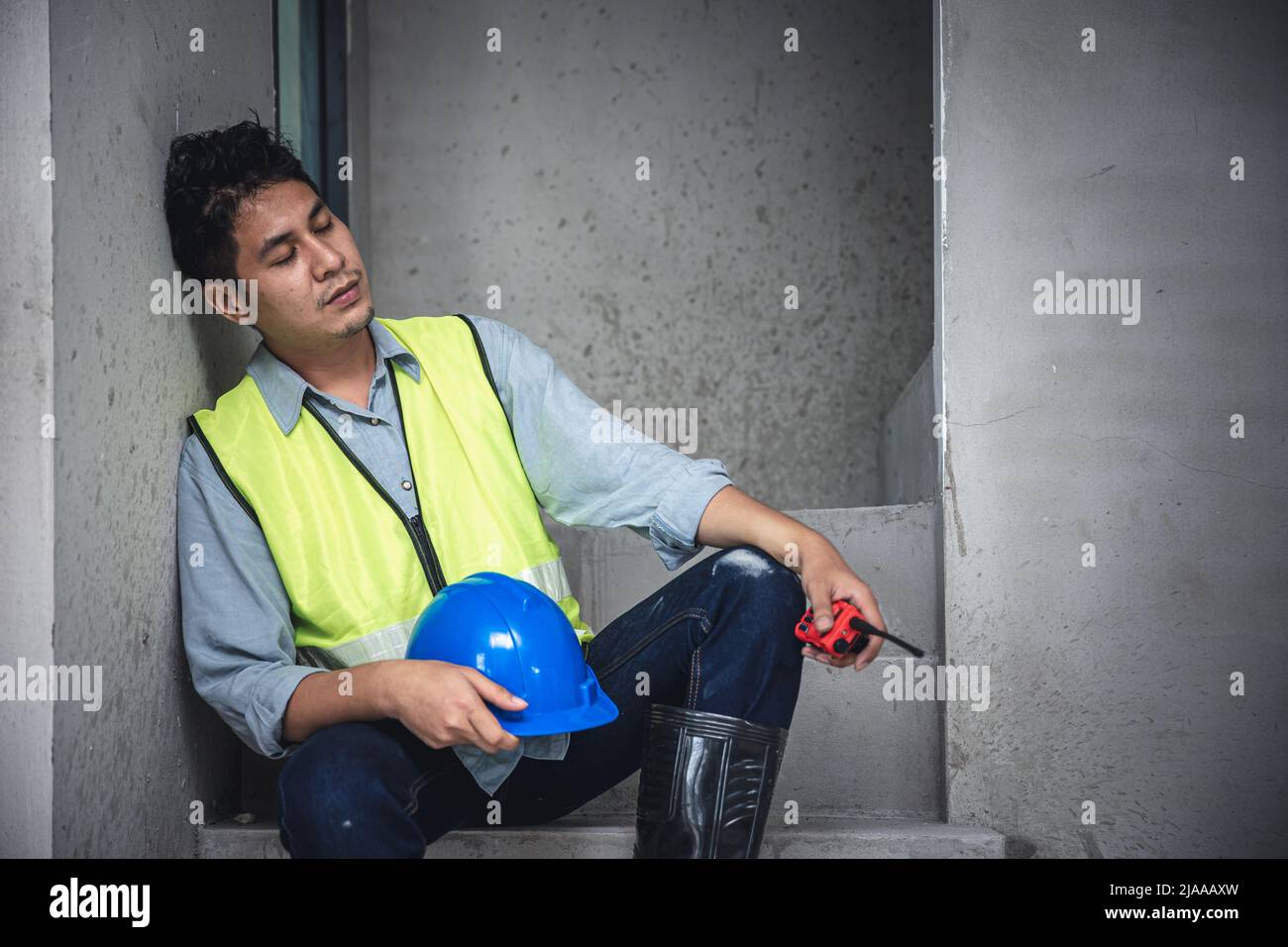 Tired exhausted and napping engineer builder worker in construction site Stock Photo