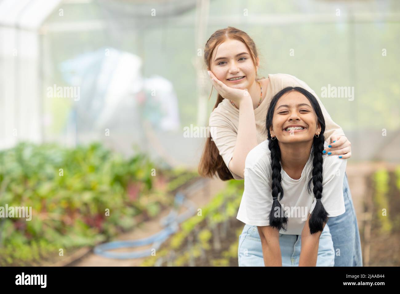 two young teenager girl happy smiling together friend mix race in park garden Stock Photo