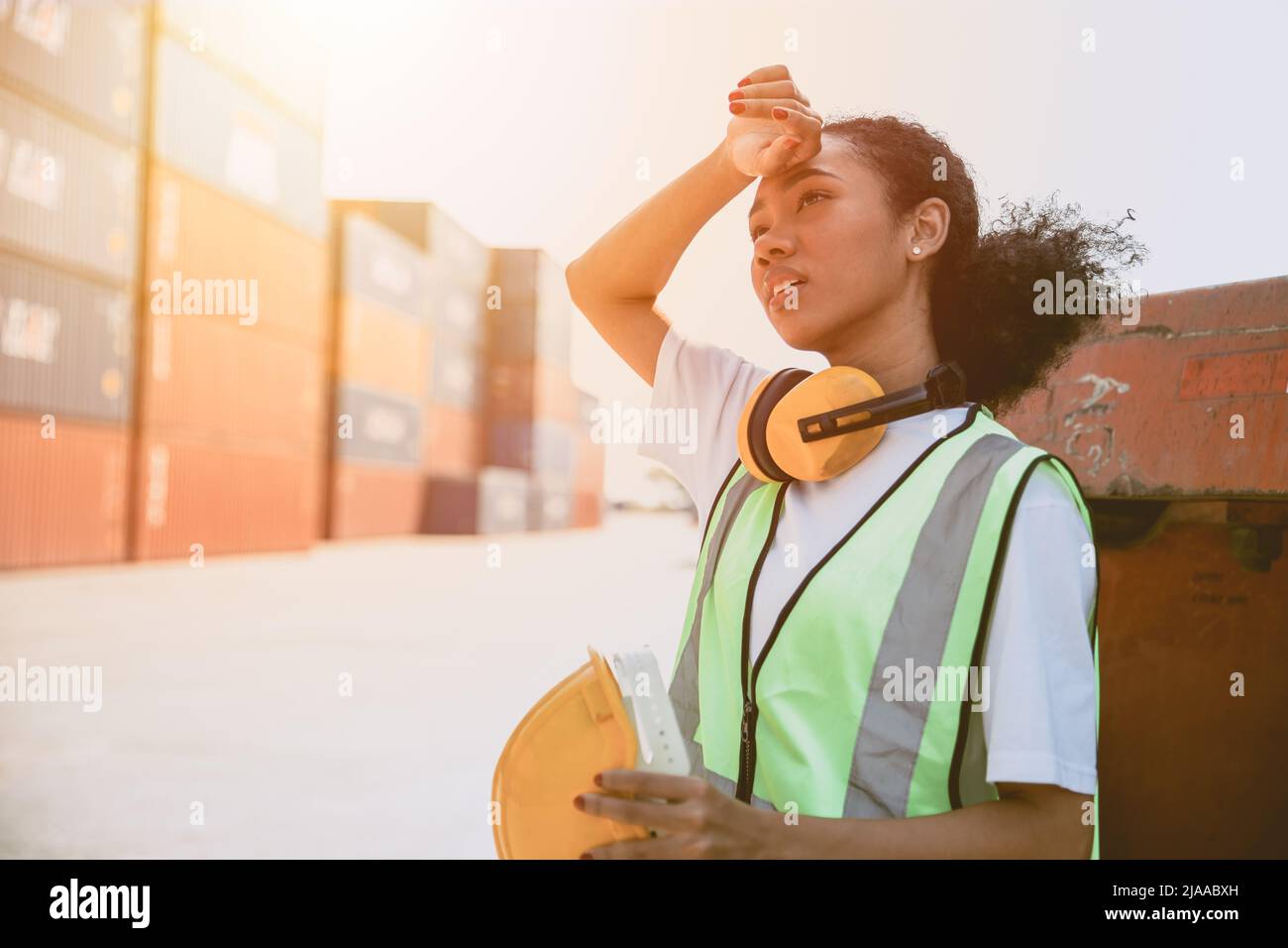 working woman worker work hard. black girl staff tired work in container port. teen lady working in danger area. young employee labor. Stock Photo
