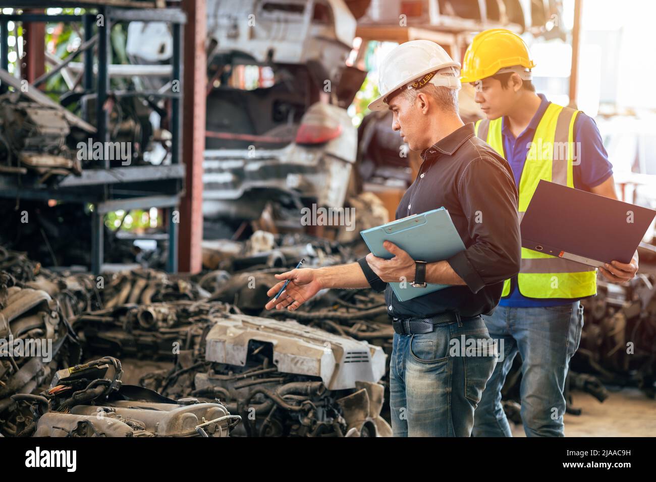 Engineer foreman manager working checking stock with young male staff worker Stock Photo