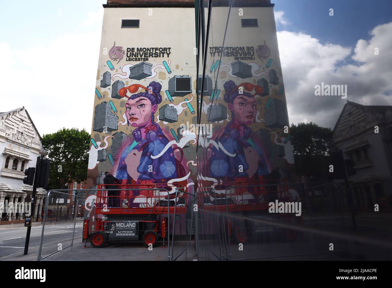 Leicester, Leicestershire, UK. 29th May 2022.  An artist is reflected in a window as he works on a mural during the Bring the Paint event. The award winning International Street Art Festival attracts artists from all over the world. Credit Darren Staples/Alamy Live News. Stock Photo