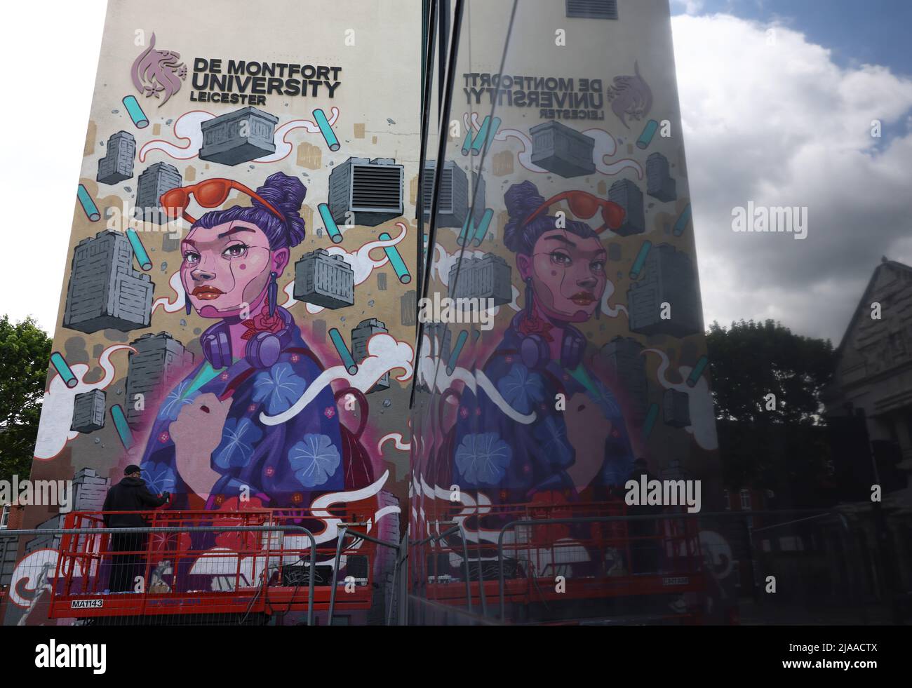 Leicester, Leicestershire, UK. 29th May 2022.  An artist is reflected in a window as he works on a mural during the Bring the Paint event. The award winning International Street Art Festival attracts artists from all over the world. Credit Darren Staples/Alamy Live News. Stock Photo