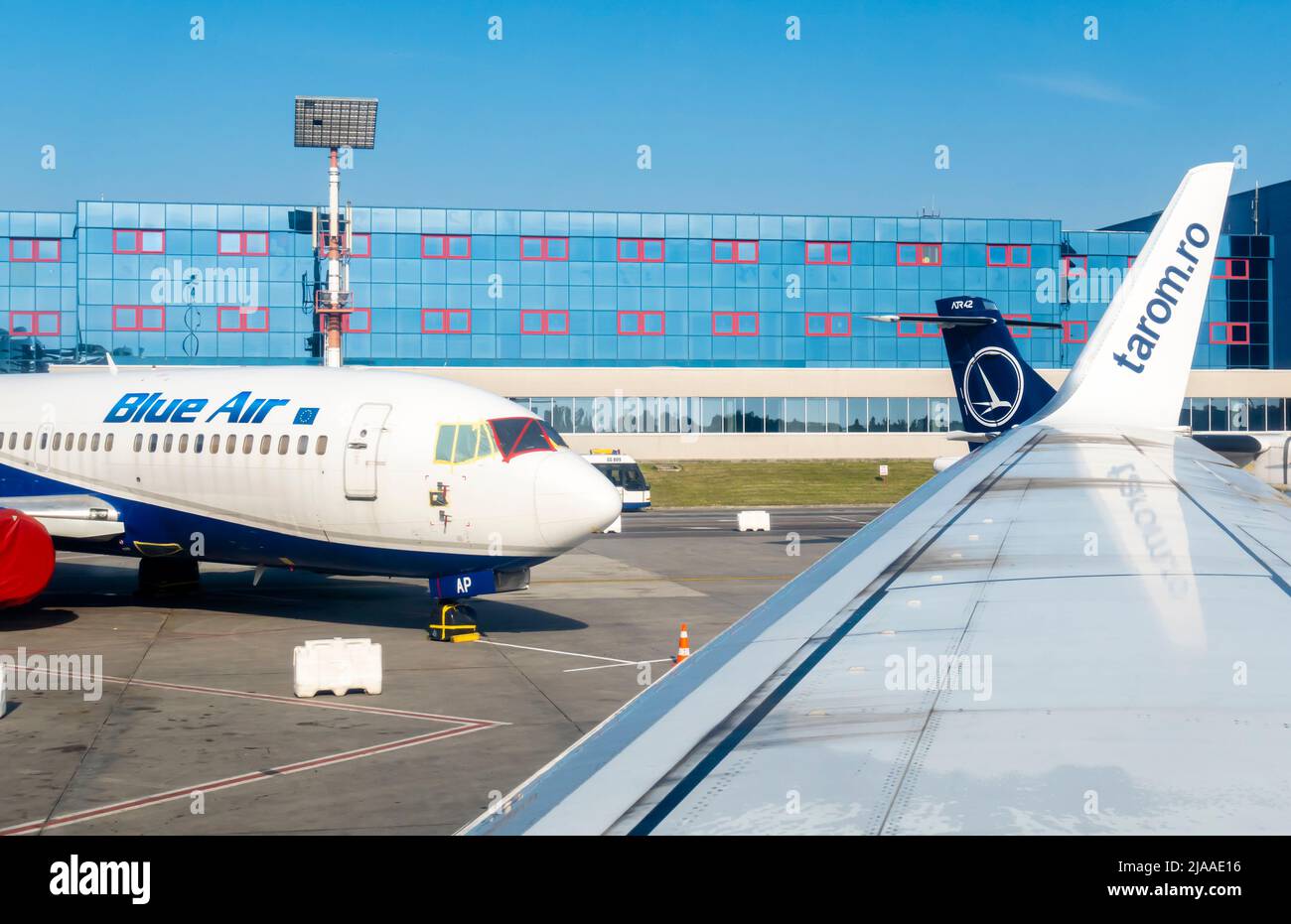 Henri Coandă International Airport, OTP, Otopeni, Romania with BlueAir at the gate. View from Tarom airplane window at wing side Stock Photo