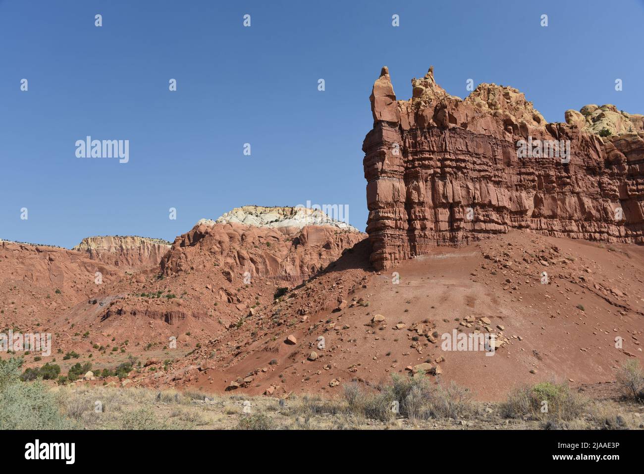 A beautifully colorful panoramic landscape of eroded sandstone formations, mesas, cliffs and mountains in Northern New Mexico. Note the full frame for Stock Photo