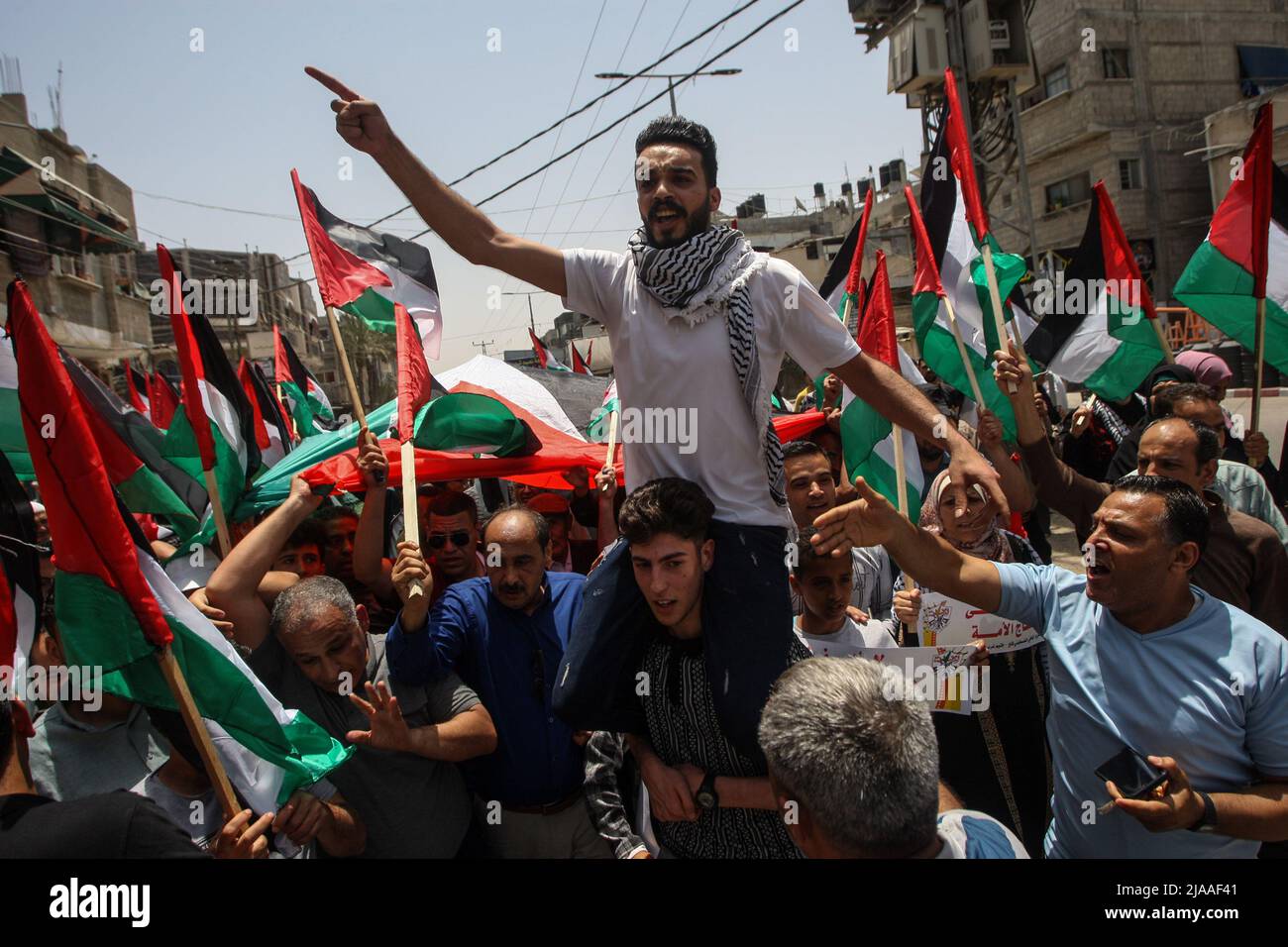 Khan Younis, Gaza. 29th May, 2022. Palestinians wave Palestinian flags during a protest over tensions in Jerusalem's Al-Aqsa Mosque, in Khan Younis, in the southern Gaza Strip, on Sunday, May 29, 2022. hours before the the Israeli 'flags march' to mark Jerusalem Day, which commemorates the unification of the city after Israel annexed east Damascus Gate in 1967. Jerusalem is bracing for a controversial "flag march" by Israelis that has sparked warnings of a new escalation from Palestinian factions. Photo by Ismael Mohamad/UPI Credit: UPI/Alamy Live News Stock Photo