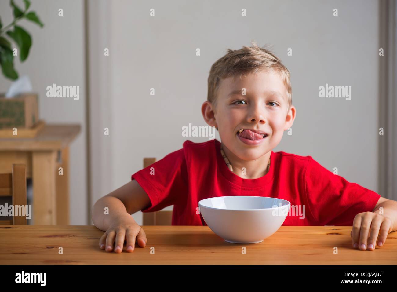 Cute boy playing with granola at breakfast. Genuine expressions Stock