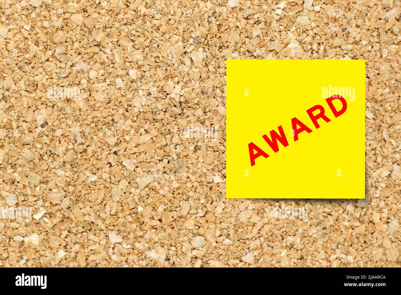 Yellow note paper with word award on cork board background with copy space Stock Photo