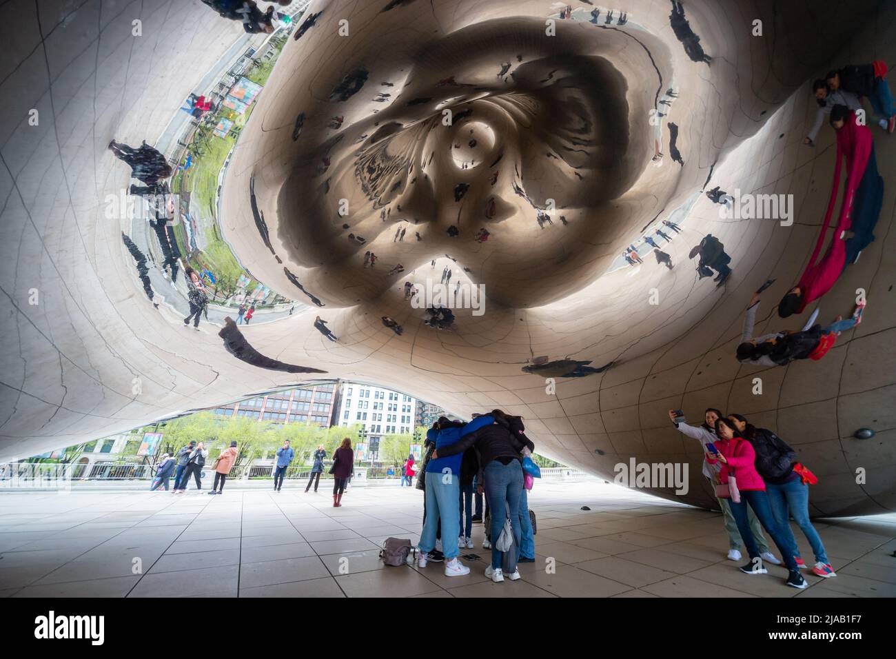 Visitors to Millennium Park Chicago gather underneath the Cloud Gate