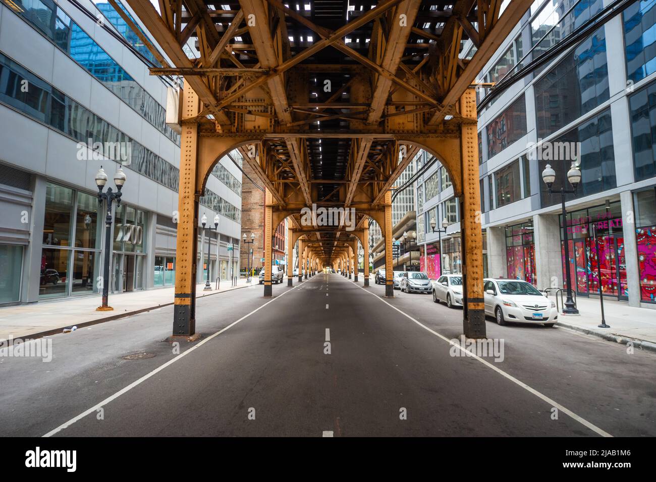 Elevated train tracks on a Chicago street, showing the track above the road, which the Chicago L rapid transit system runs on. IL, USA. Under the El Stock Photo