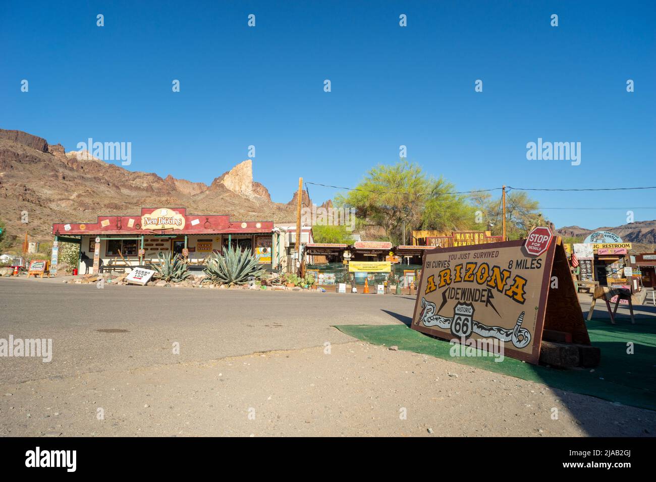 Main street of Oatman, Arizona, USA. A sign marks the end of the road into the town, the 'Arizona Sidewinder', 8 miles with 191 curves or corners Stock Photo