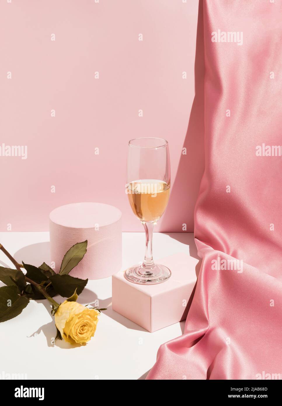 Romantic pastel pink Valentine's Day composition with wine glass, satin ...