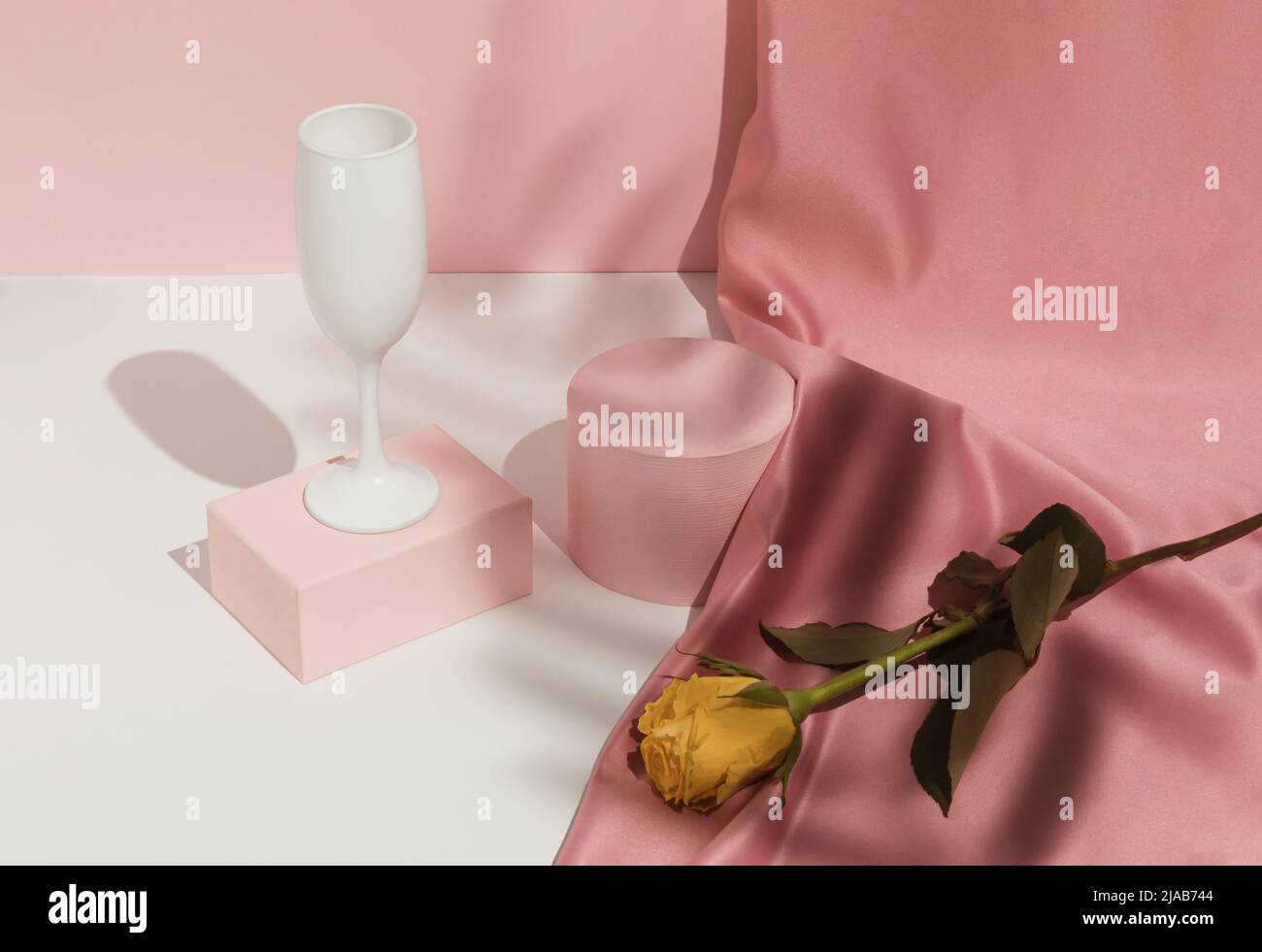 Romantic pastel pink Valentine's Day composition with wine glass, satin ...