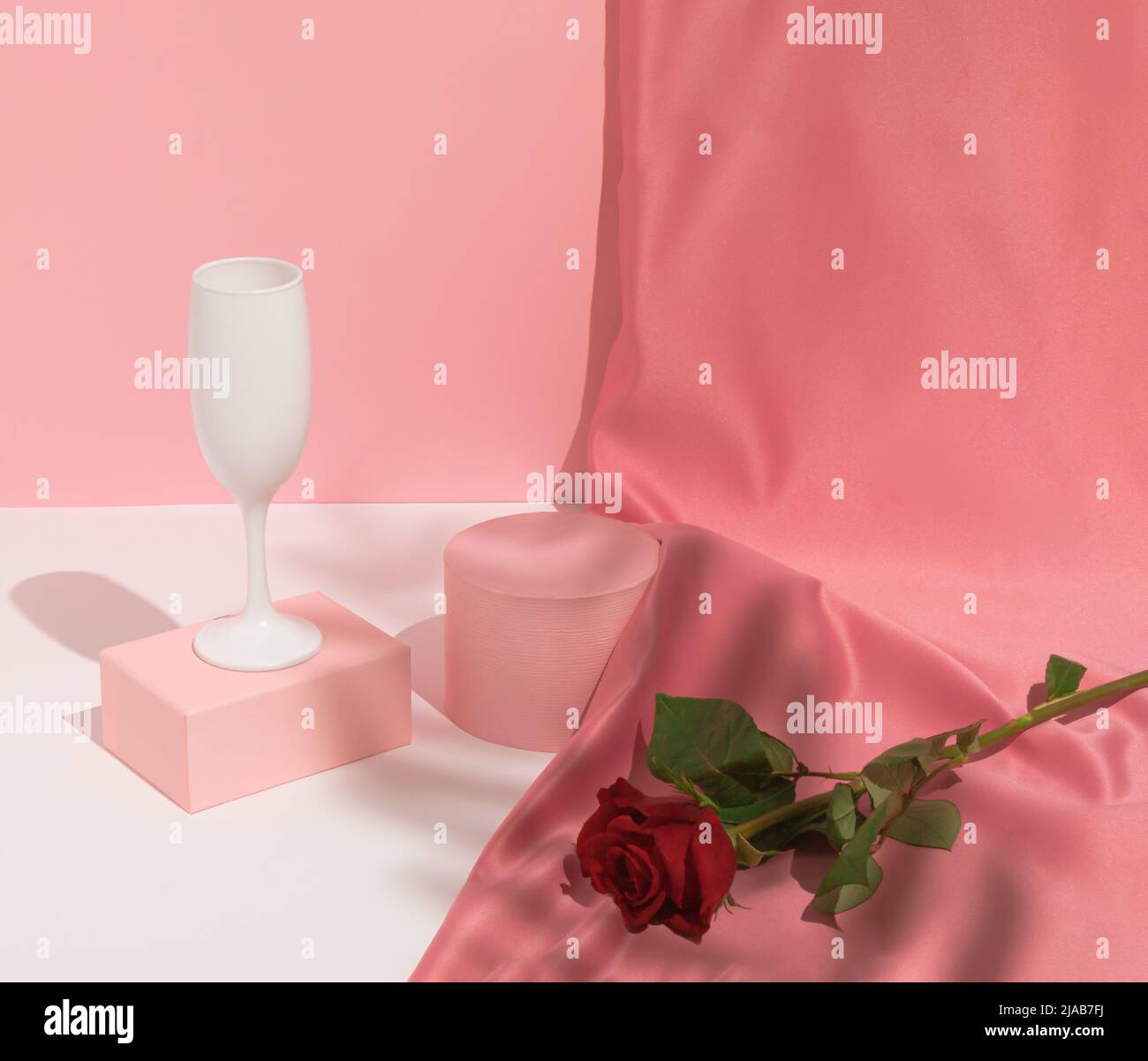 Romantic pastel pink Valentine's Day composition with wine glass, satin ...