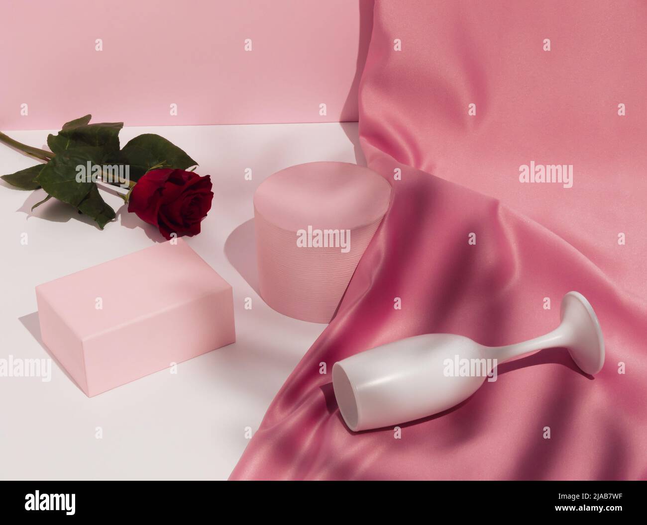 Romantic pastel pink Valentine's Day composition with wine glass, satin ...