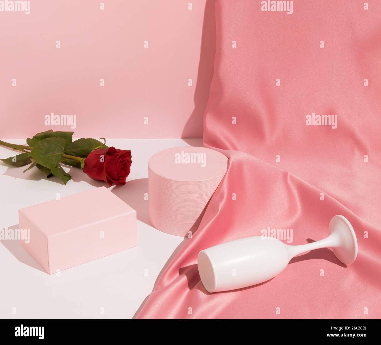 Romantic pastel pink Valentine's Day composition with wine glass, satin ...