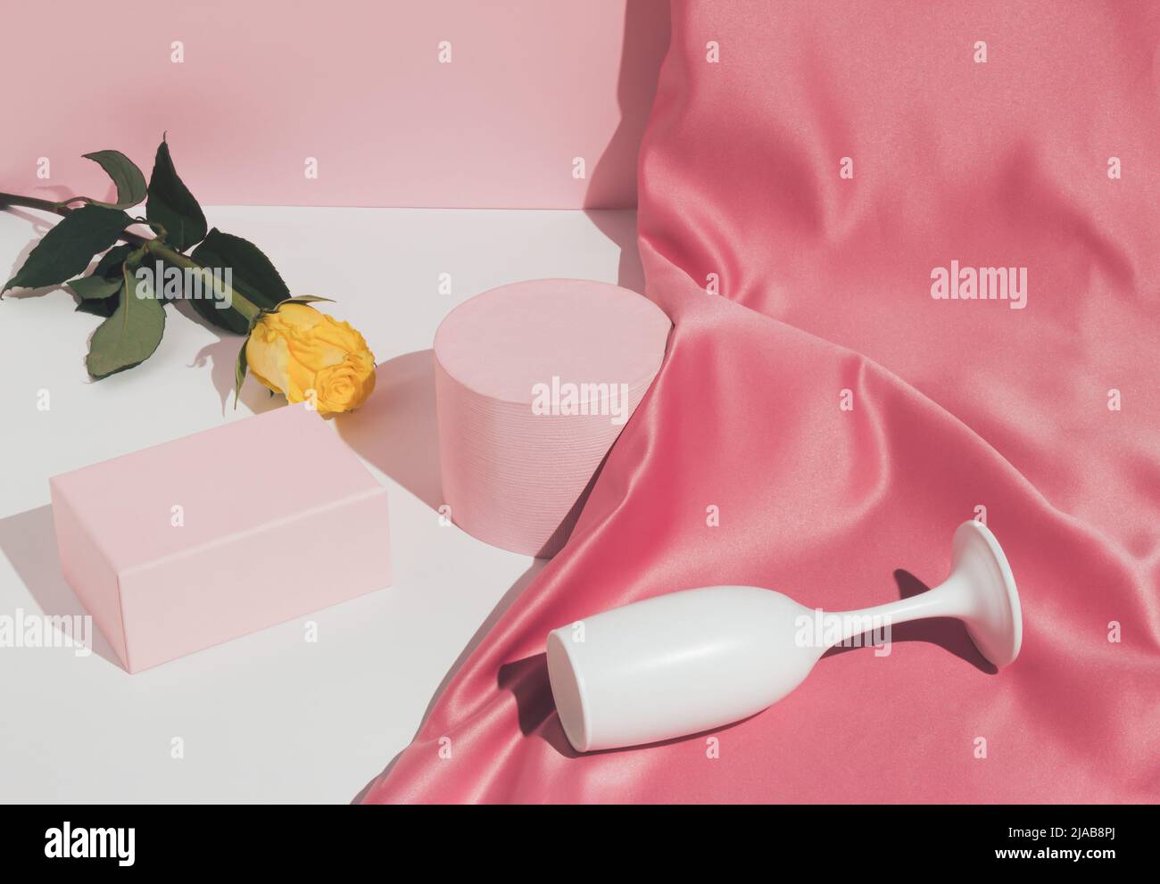 Romantic pastel pink Valentine's Day composition with wine glass, satin ...