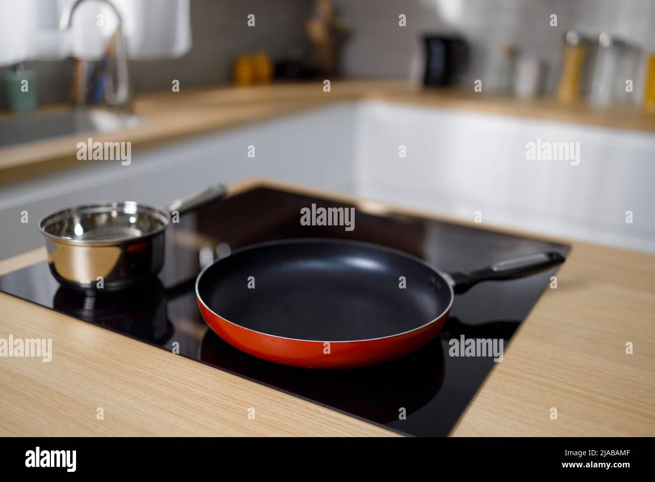 Frying pan and sauce pan on induction hob in modern kitchen Stock Photo