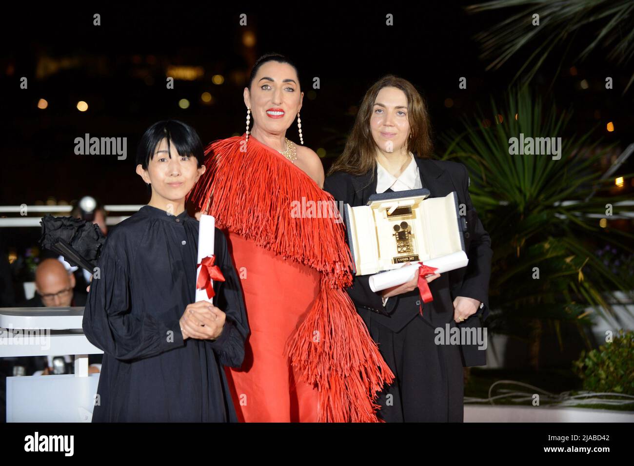 May 28, 2022, CANNES, France: CANNES, FRANCE - MAY 28: President of the Camera d'or jury, Rossy De Palma (C) poses with Director Chie Hayakawa (L) who won the Special Mention for a first film winner for ''Plan 75'' and Director Gina Gammell (R) who won the CamÃ©ra dâ€™or Award for a first film for ''War Pony'' at the winner photocall during the 75th annual Cannes film festival at Palais des Festivals on May 28, 2022 in Cannes, France. (Credit Image: © Frederick Injimbert/ZUMA Press Wire) Stock Photo