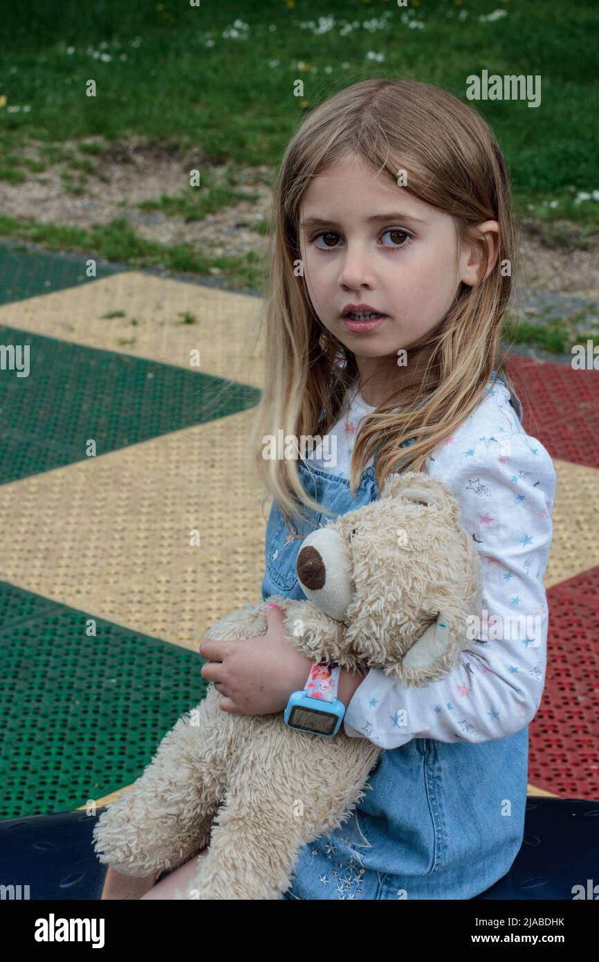 5 Year Old Girl Plays In Park While Holding Her Teddy Bear Stock Photo 5-year-old-girl-plays-in-park-while-holding-her-teddy-bear-stock-photo