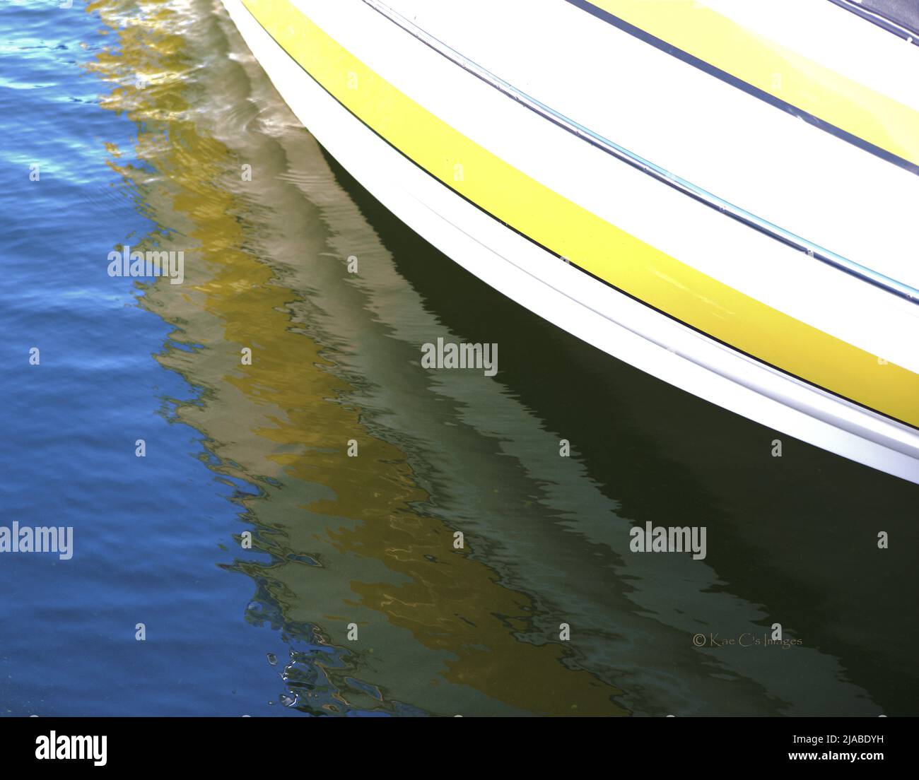 Abstract boat with white ahd hellow bands, reflected on the water. Stock Photo