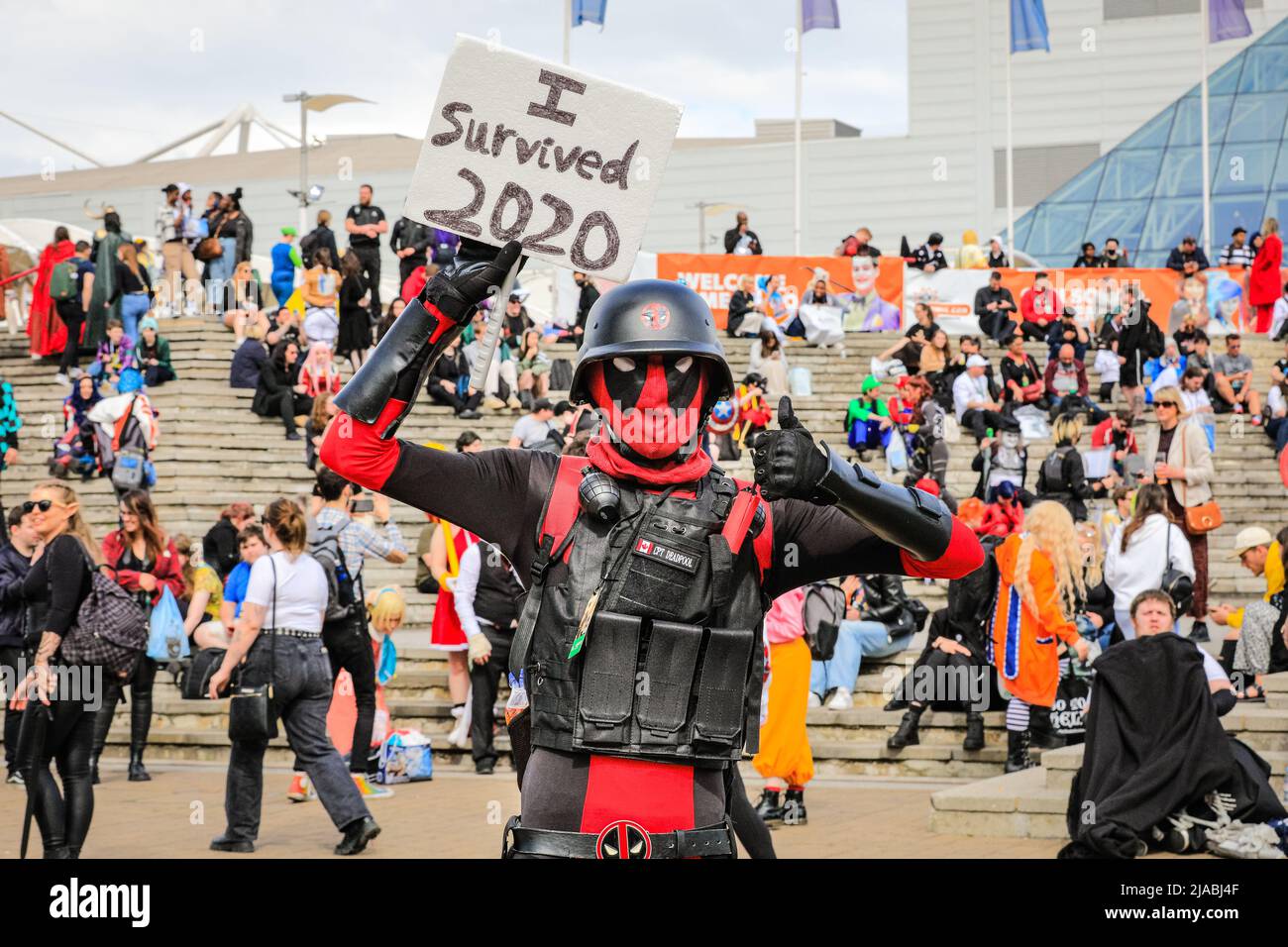 London, UK. 29th May, 2022. A cosplayer in post-apocalyptic outfit holds up a 'I survived 2020' sign. Cosplayers, costumed characters, fans of anime, comics, games and film once again get together for fun, stalls, entertainment and posing at ExCel London for the MCM Comic Com, for the final day of the well attended show. Credit: Imageplotter/Alamy Live News Stock Photo