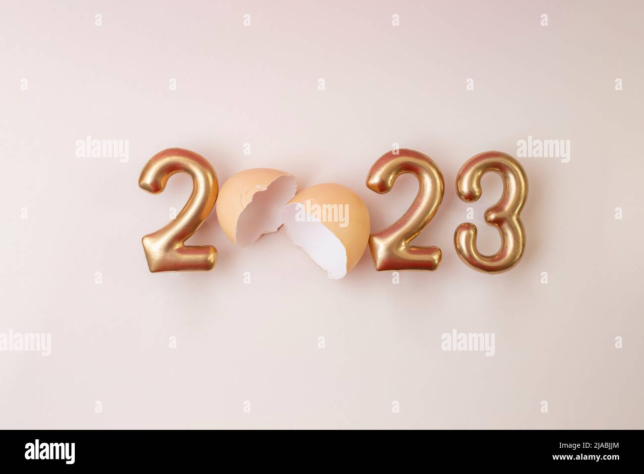 2023 written with golden letters and an egg shell, happy new year beige card design Stock Photo