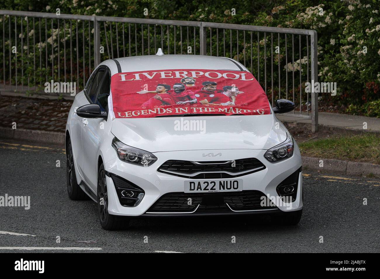 A car is covered with a Liverpool FC flag as the open top bus parade travels through the city Stock Photo