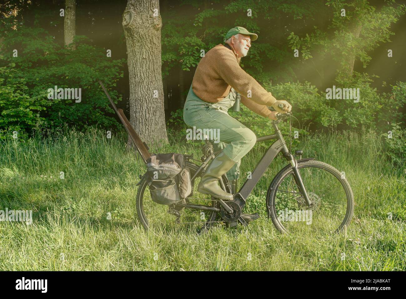 Eco-hunting in harmony with nature. That's why this hunter goes hunting early in the morning on his e-bike and leaves his big SUV in the garage. Stock Photo