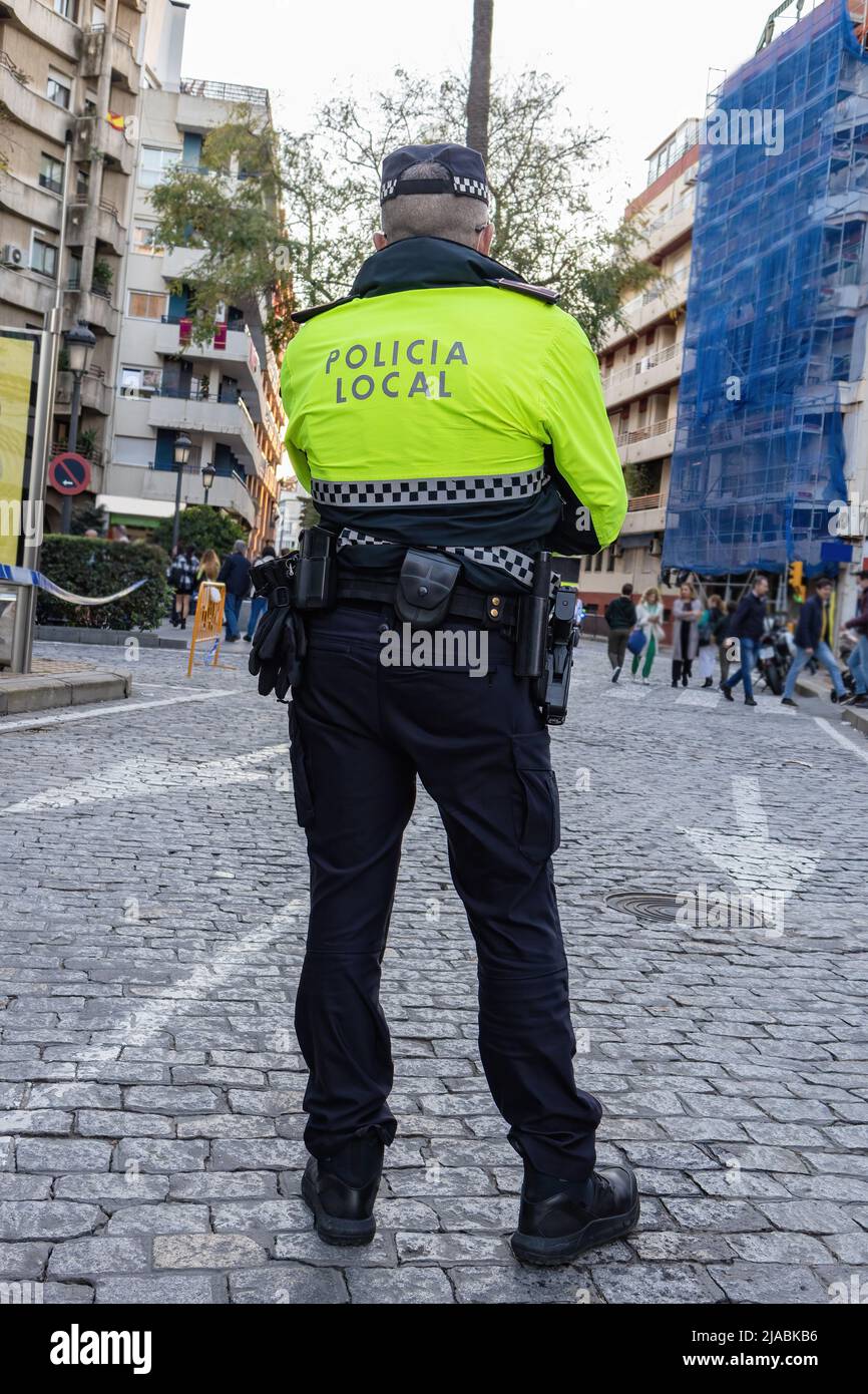Back view of a police with the text in spanish 'Policia Local' that means local police maintaining the order in the streets Stock Photo