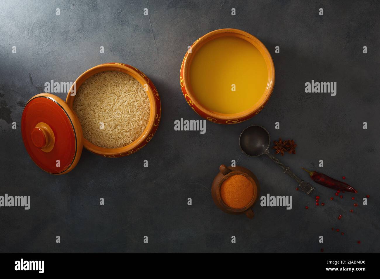 Homemade ghee, rice in a ceramic pot, red peppers and turmeric spices