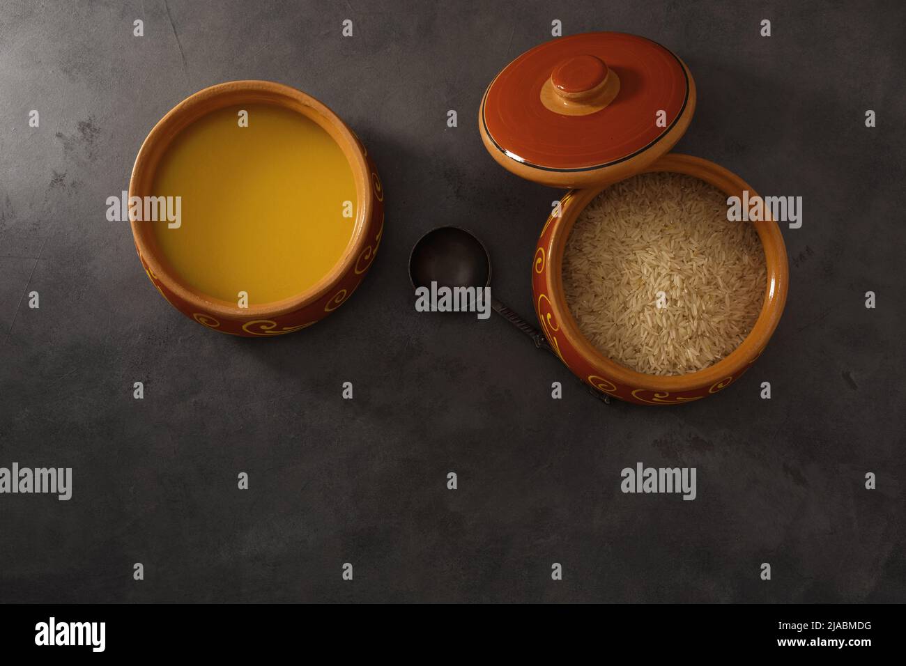 Homemade ghee, rice in a ceramic pot, red peppers and turmeric spices